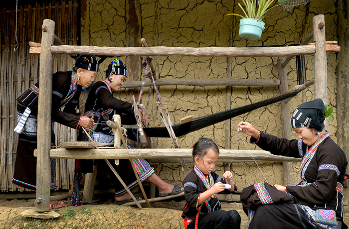 The Lu people gather around to embroider and weave  together. Photo: Nguyen Thi Thuy Nga